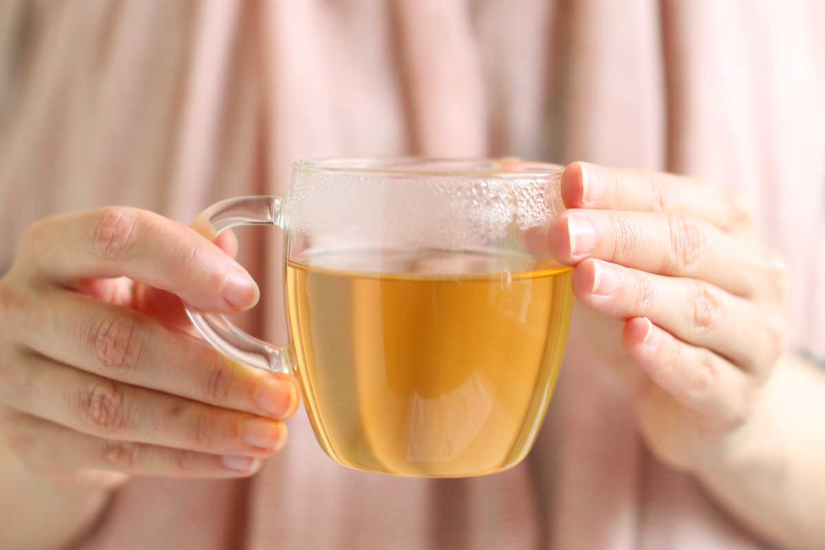 Hands holding a cup of green tea