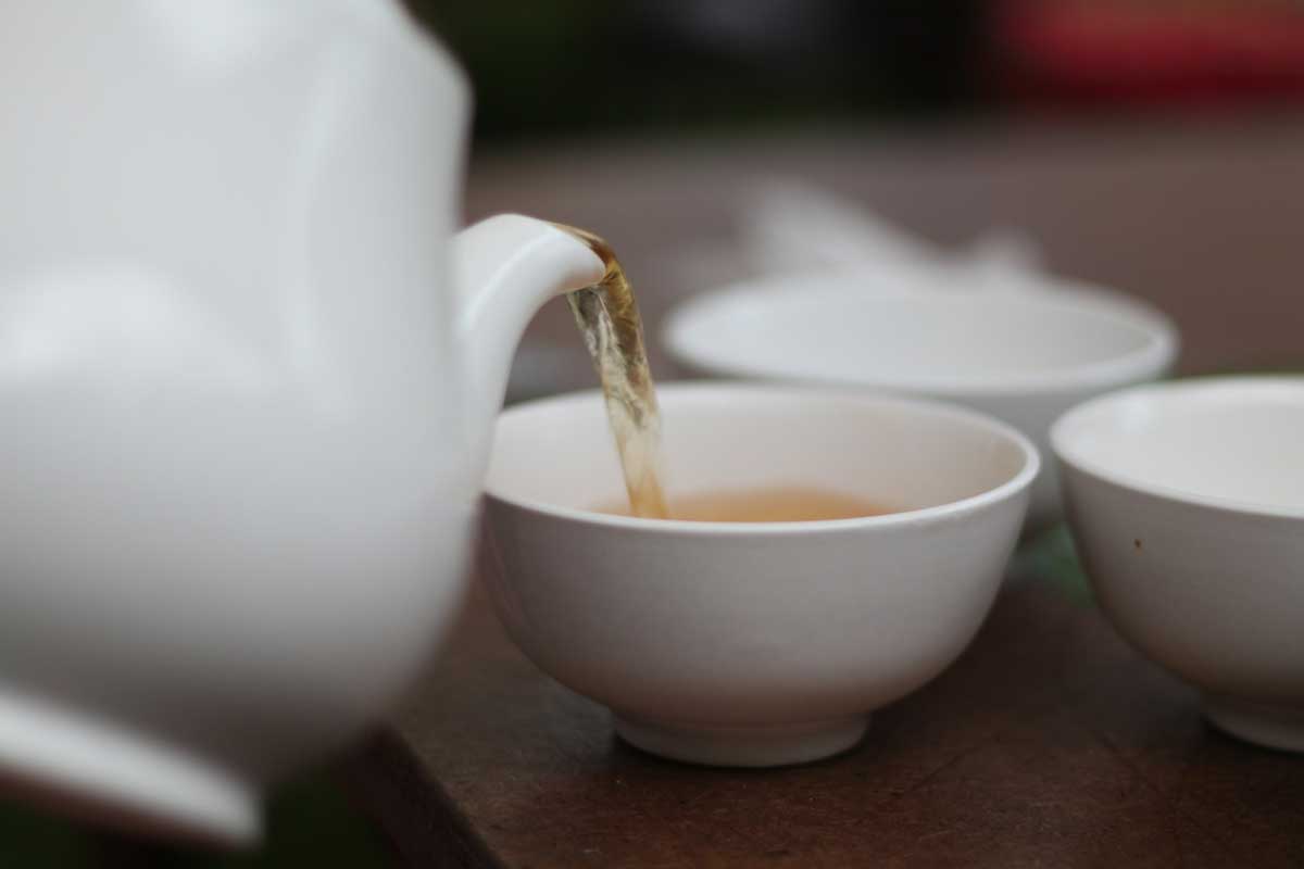 Pouring green tea into a cup