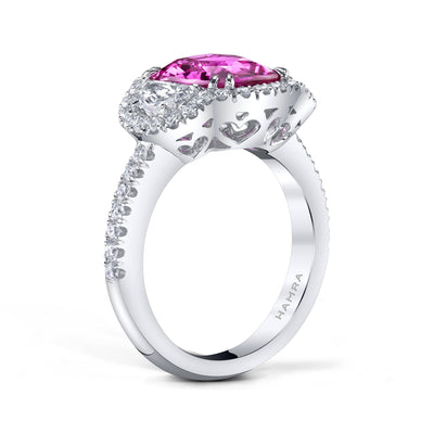 Custom made gemstone ring featuring a 4.09 carat cushion cut pink sapphire center with two .60 carat half moon diamond side stones and .60 carats total weight in round brilliant cut accent diamonds set in platinum.