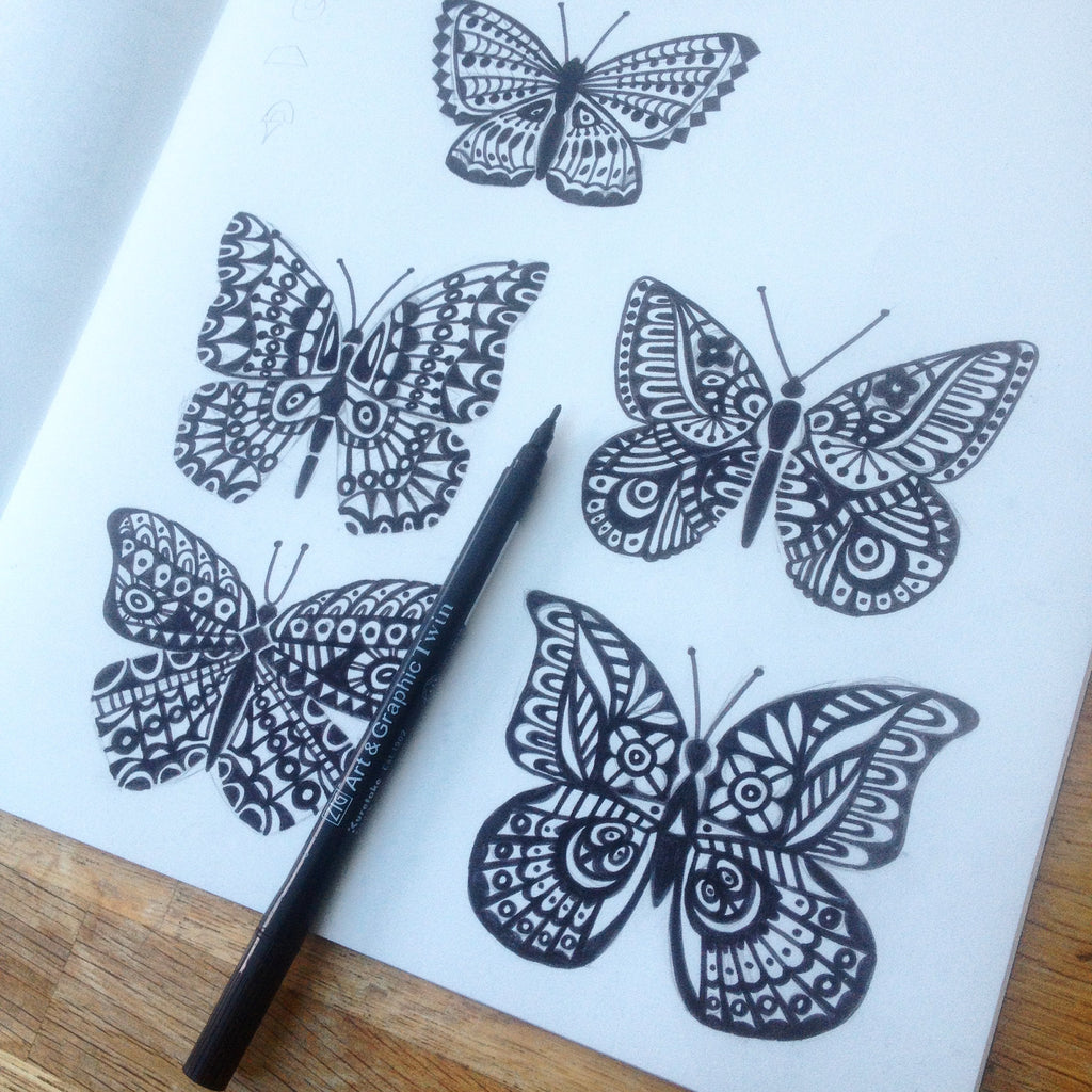 Sketching detailed butterflies with black markers by hand for a new screen print collection.