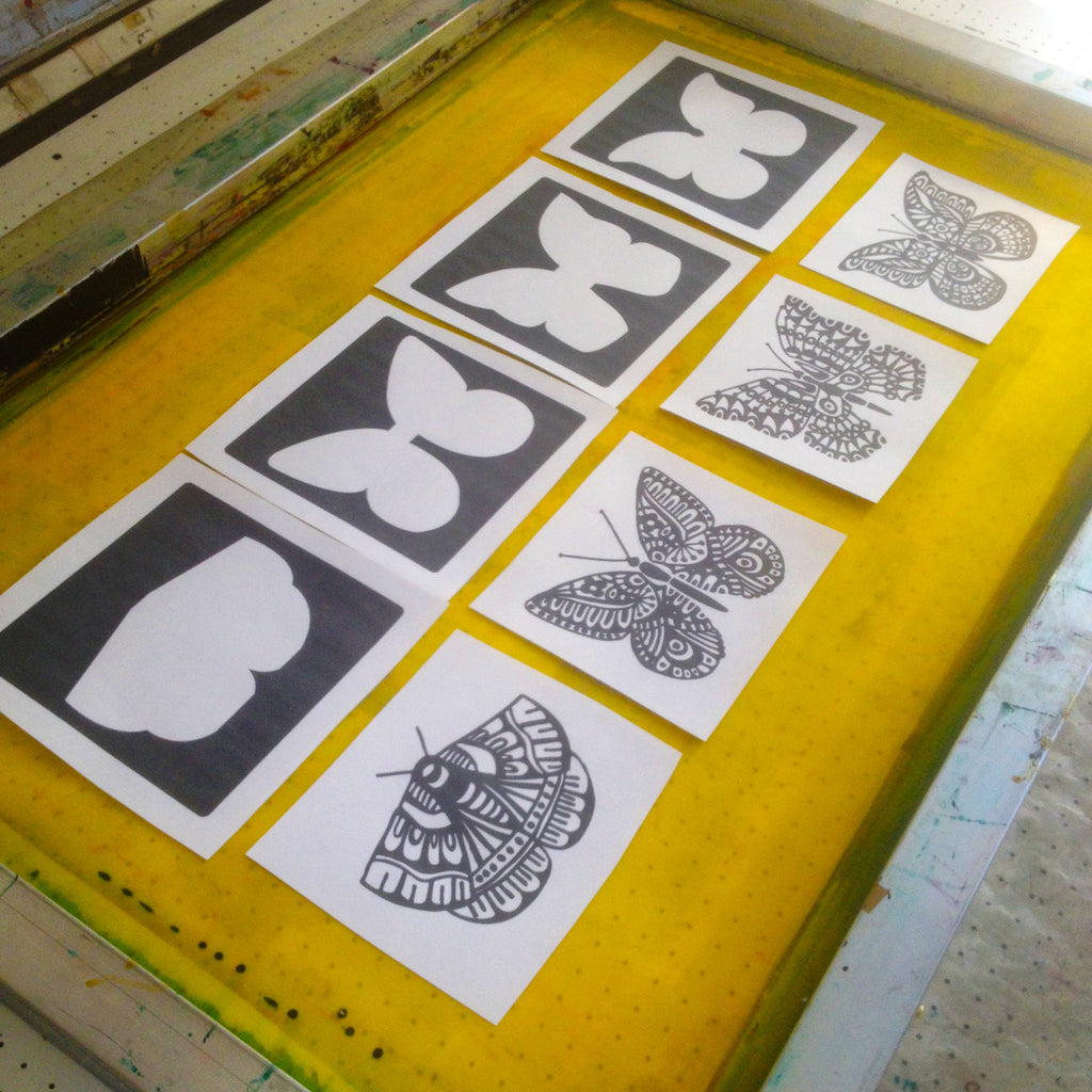 Paper templates of the four butterfly prints are laid out onto the mesh screen for exposure.