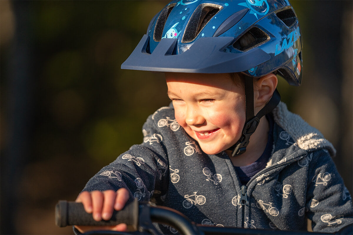 Young boy riding his bike wearing a Lazer Lil' Gekko MIPS bicycle helmet