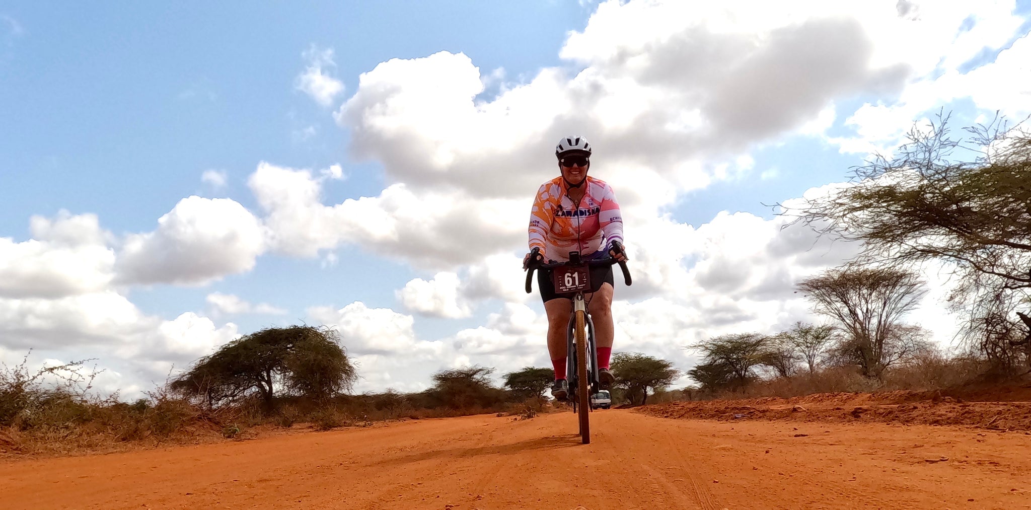Crystal riding her gravel bike in kenya wearing a Lazer strada kineticore road bike helmet