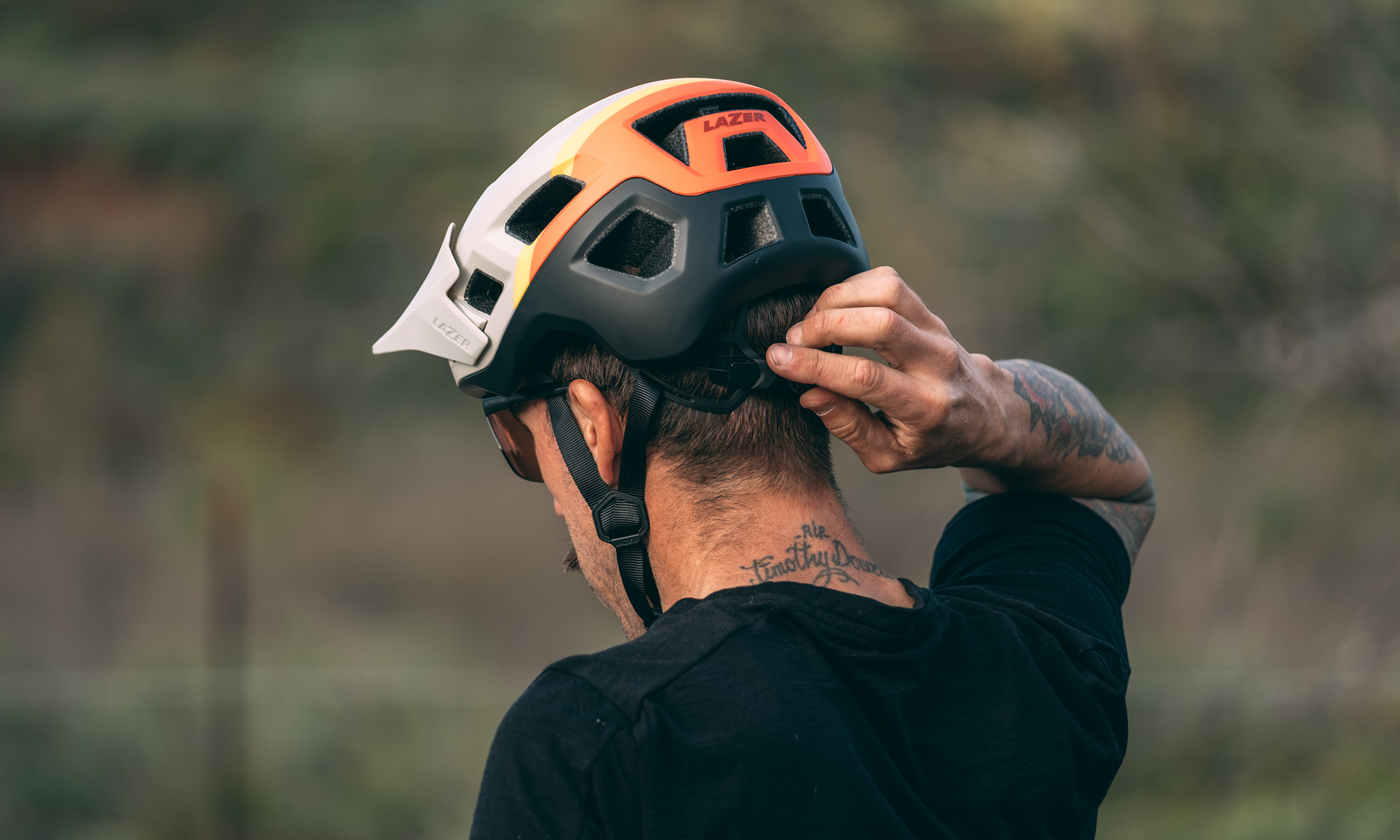 Man adjusting his Lazer Coyote KinetiCore mountain bike helmet 