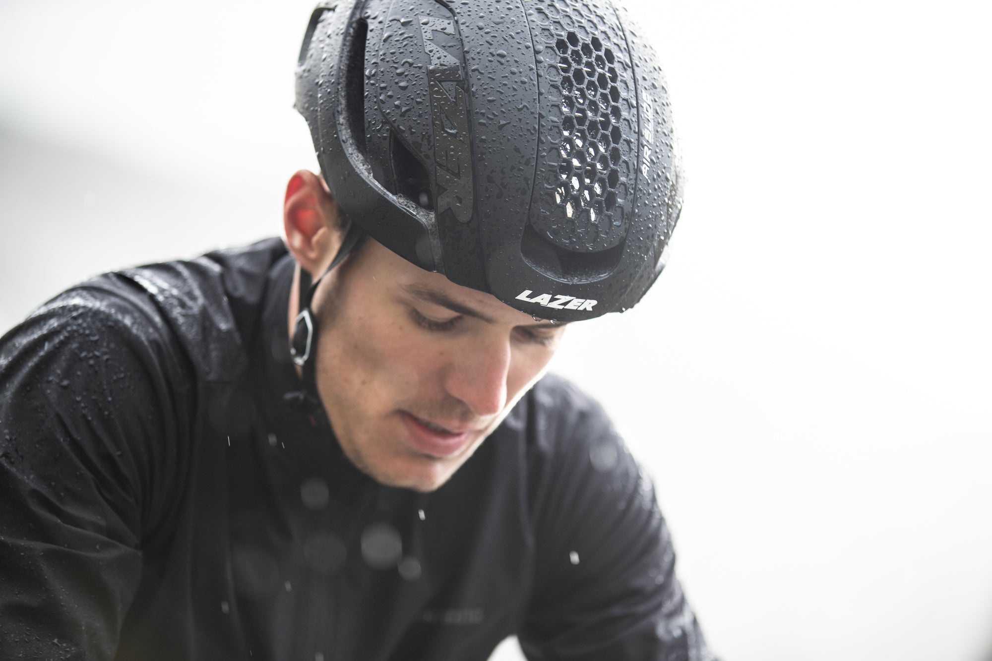 man wearing a lazer road bike helmet in the rain
