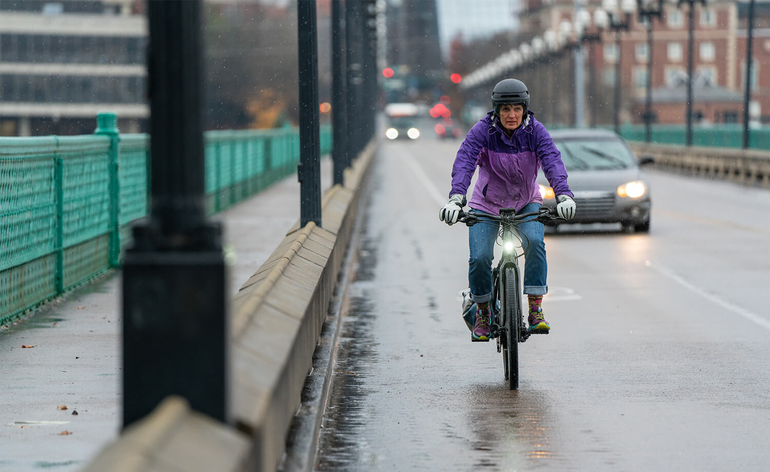 Lady wearing a Lazer Urbanize MIPS helmet on her rainy bike commute to work