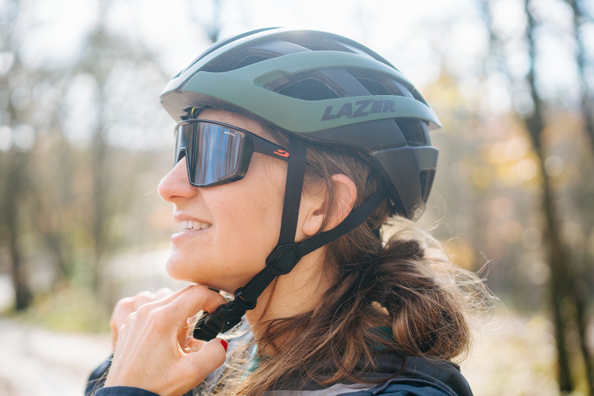 Women buckling her Lazer G1 MIPS road helmet