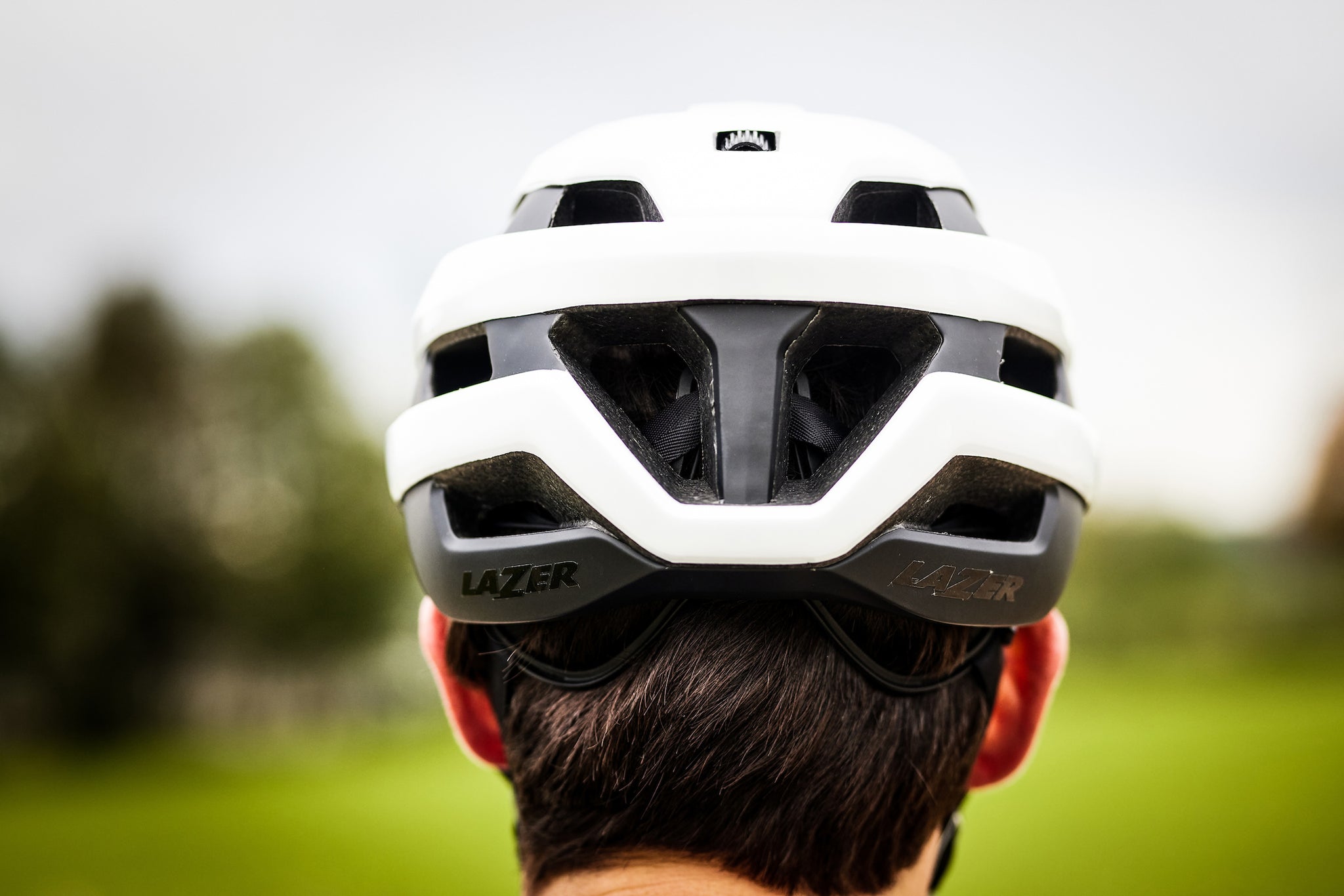 Back of a guys head wearing a Lazer Sphere MIPS road cycling helmet white