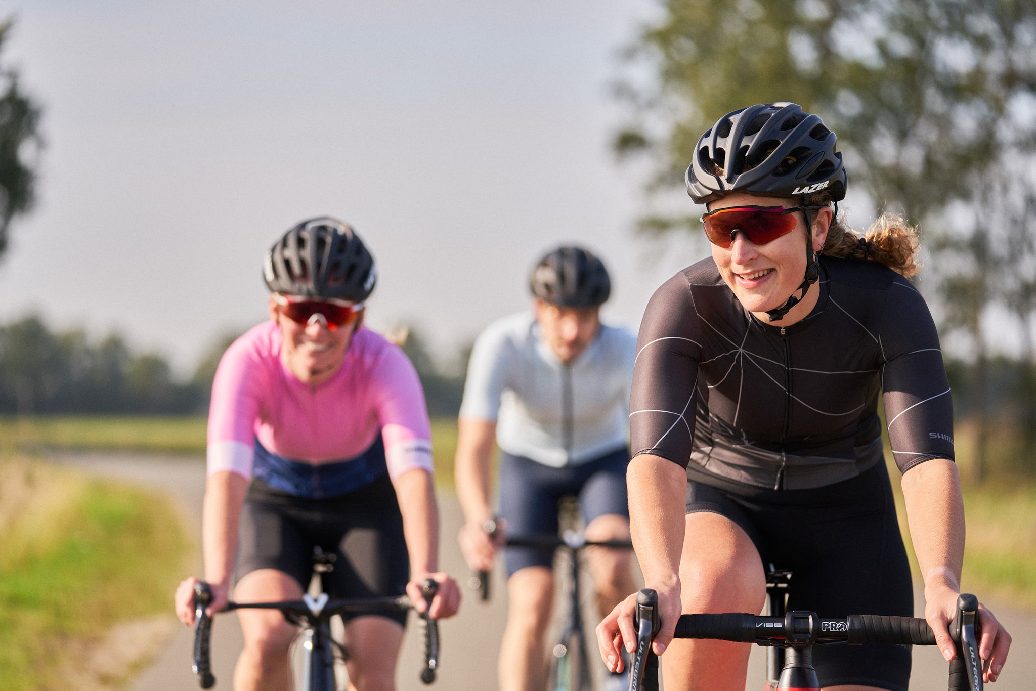 Group of women riding road bikes wearing Lazer helmets