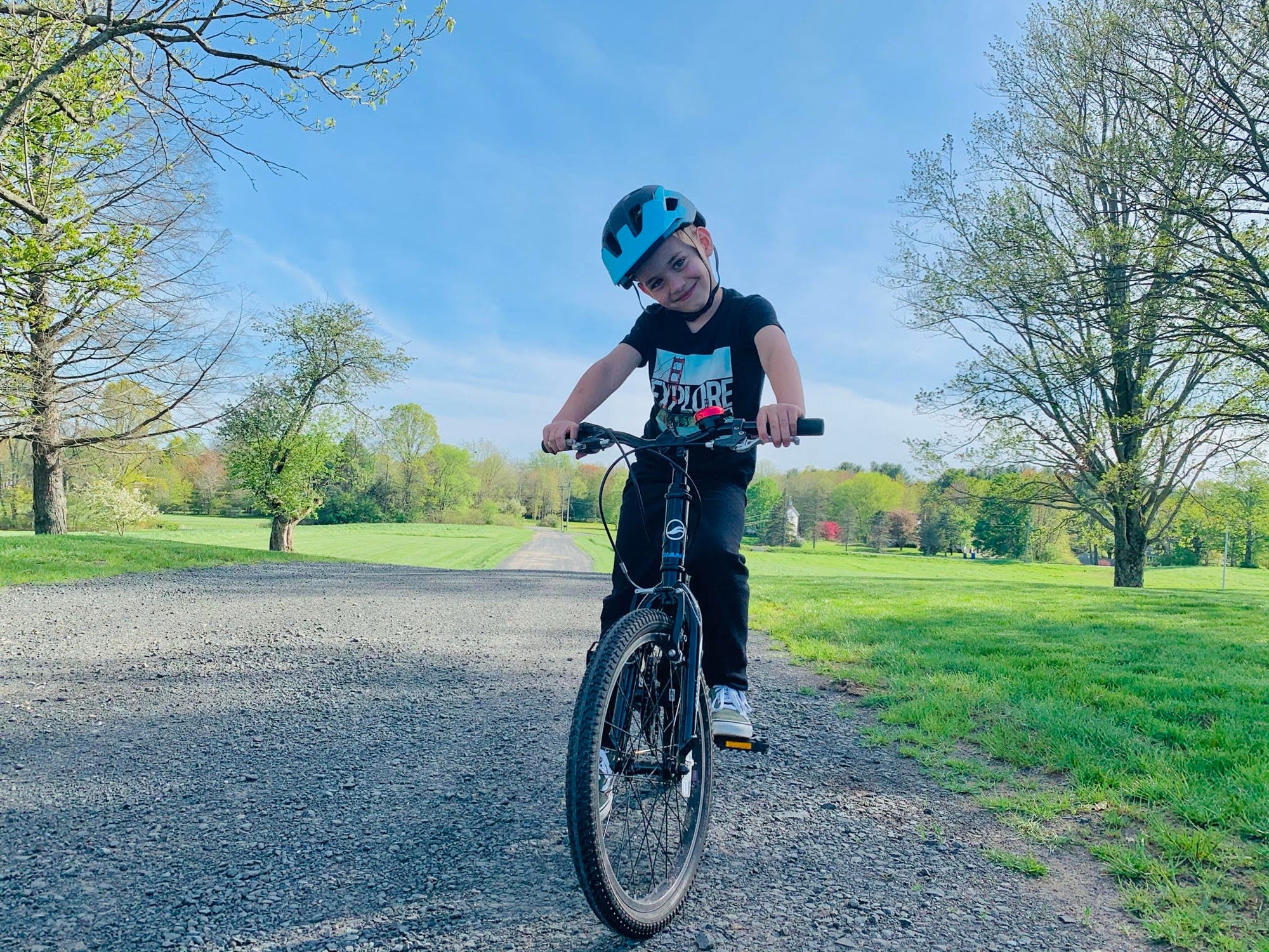 Young kid wearing a Lazer Kids bike helmet while riding his bicycle