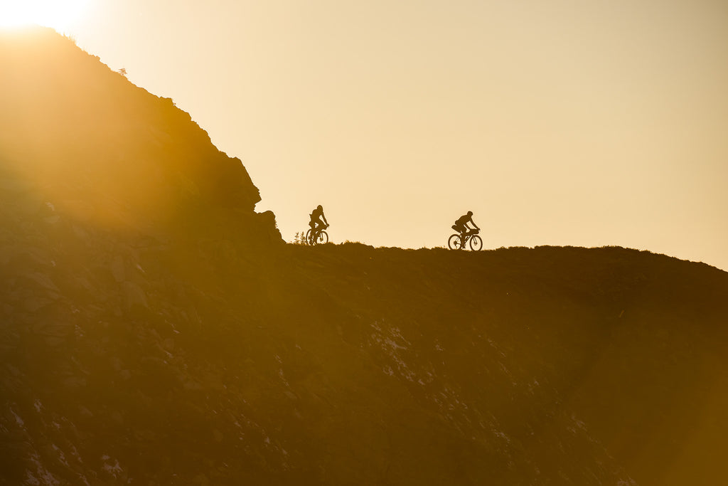 Svein Tuft riding his gravel bike in the mountains at sunset