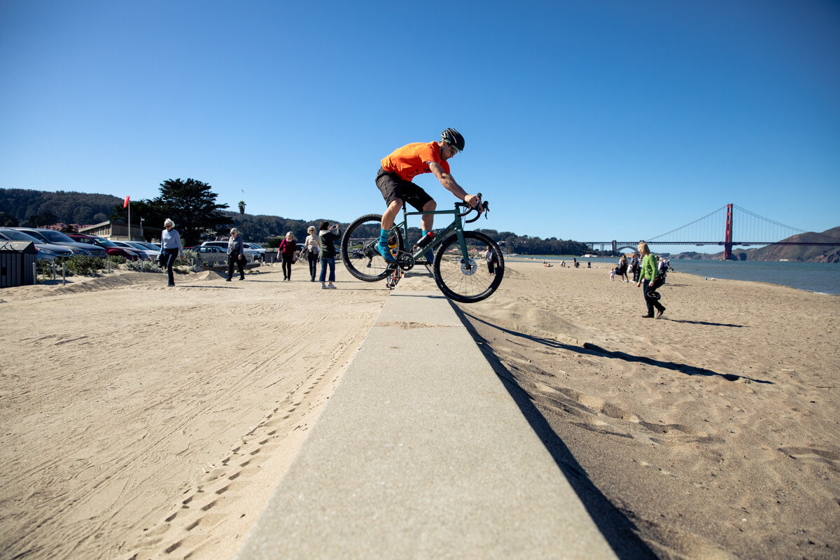 Jumping gravel bike at the beach in SF wearing a Z1 MIPS road cycling helmet 