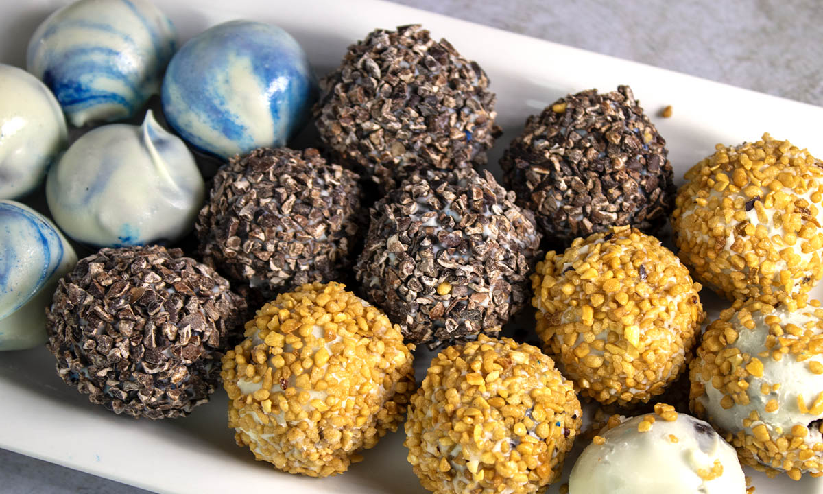 vegan chocolate truffles, topped with white chocolate, cocoa nibs, hazelnuts bite