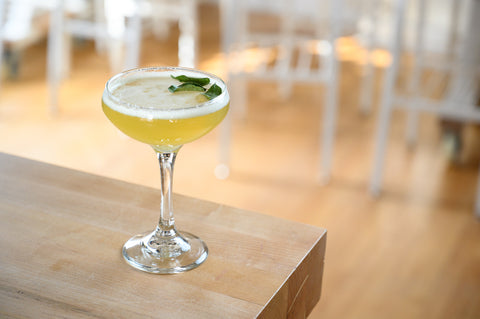Beachcomber non-alcoholic cocktail in a coupe glass garnished with curry leaves