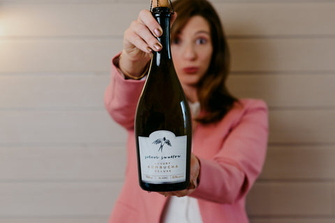 CEO & Co-Founder Genna holds a bottle of Silver Swallow Blanc in front of her