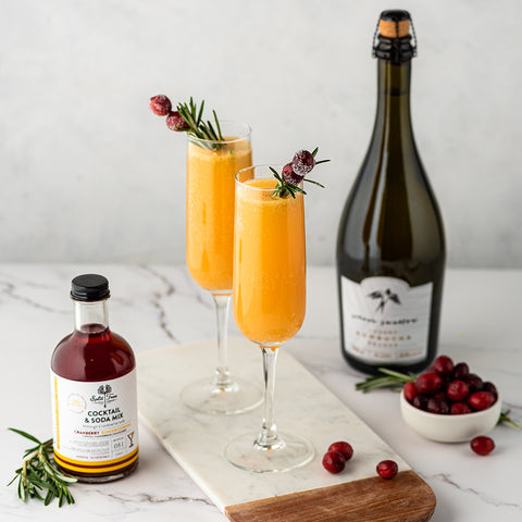 Festive Cran Mimosa beside bottles of Silver Swallow and Split Tree Cranberry and Ginger Cordial