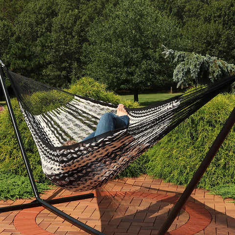 Woman laying in hammock on her patio