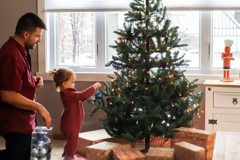 Father and daughter decorating a Christmas tree