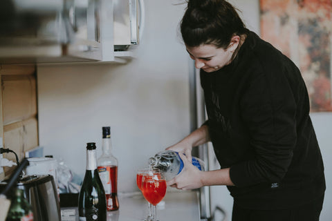 Woman pouring drinks in kitchen