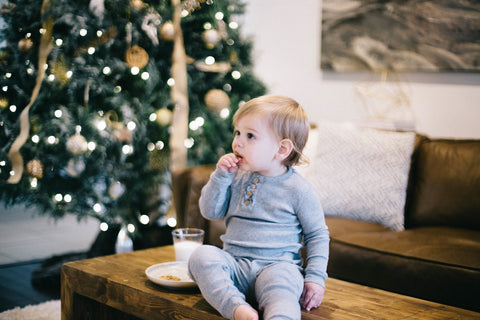 Child sitting in front of a Christmas tree