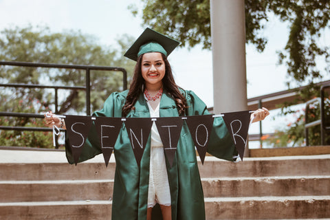 Girl in graduate robe holding garland