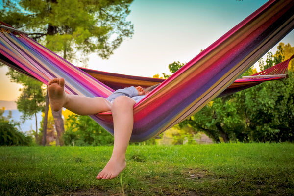 Person laying comfortably in a brazilian hammock.