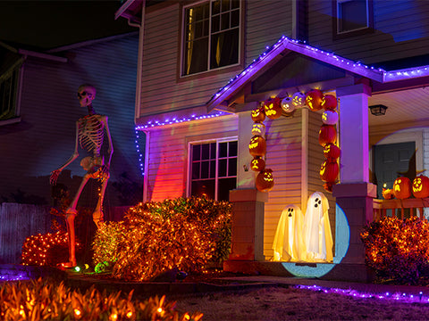 front yard lit up for Halloween with giant skeleton
