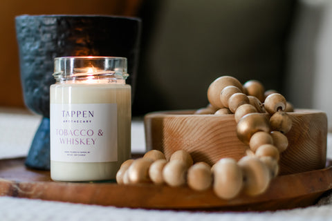 Tappen Apothecary candle with wooden pearls and a black concrete cup in the background. Photo taken in Salmon Arm