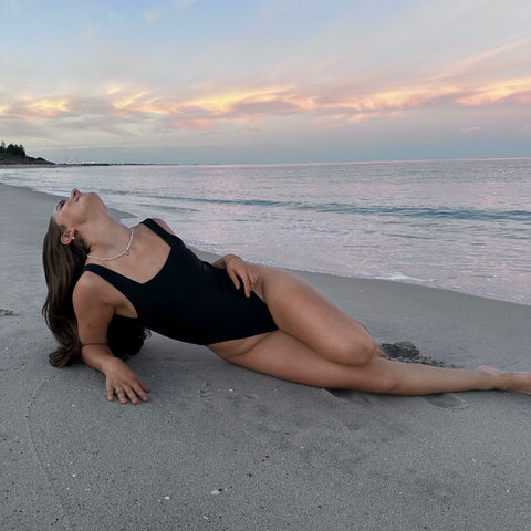 woman laying on beach at sunrise