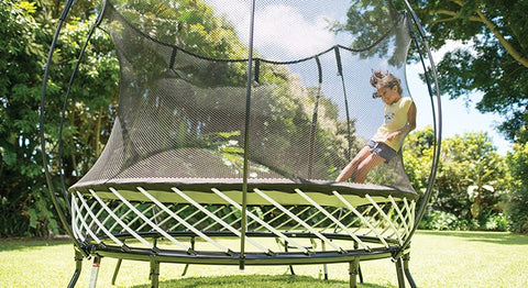 A child leaning against the Springfree Trampoline Net.