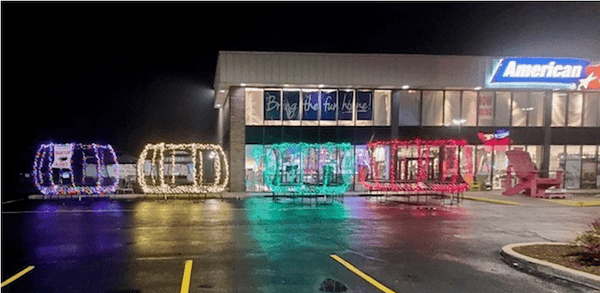 Springfree Trampolines with Christmas lights on display in front of a store at night.