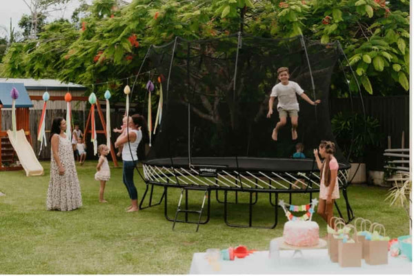 A kid jumping on a Springfree Trampoline at a birthday party.