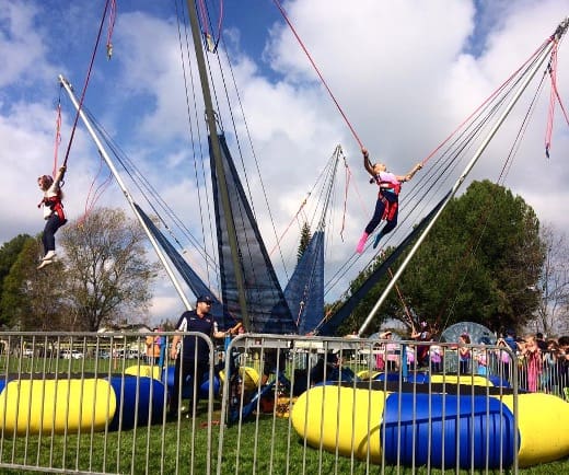 Kids jumping on bungee trampolines.