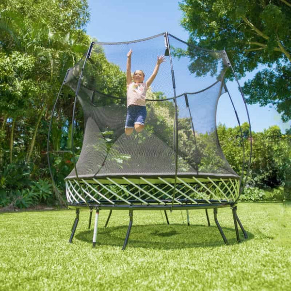 Little girl jumping on a Springfree Compact Round Trampoline.