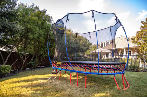 A Springfree Trampoline with red mat rods and a blue frame.