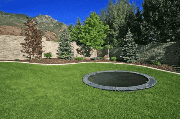 A discreet inground trampoline in a backyard.