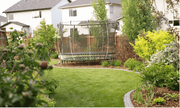 A Springfree Trampoline with green mat rods in a garden.