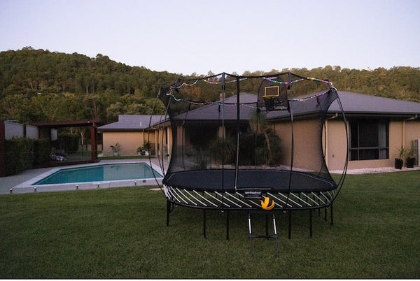 A Springfree Trampoline with a hoop and ladder.