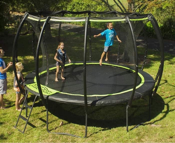 Two kids jumping on a Jumpflex Trampoline while two other people watch from the outside.