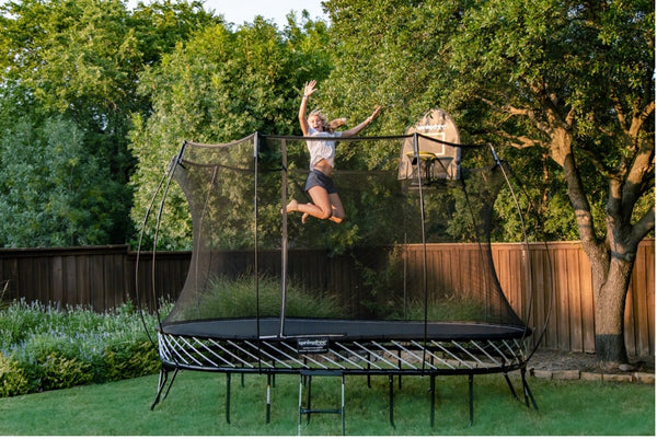 Woman jumping high on a Springfree Trampoline.