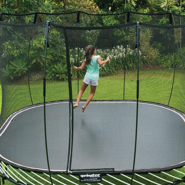 A girl jumping on a square trampoline.