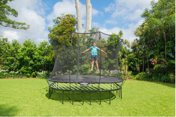 A child jumping in mid air on a Springfree Square Trampoline.