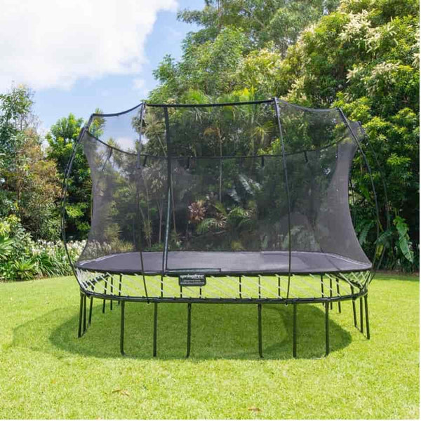 A Springfree Trampoline in a backyard on a sunny day.