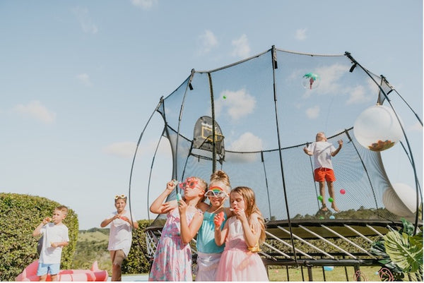 Kids playing around a Springfree Trampoline at a party.