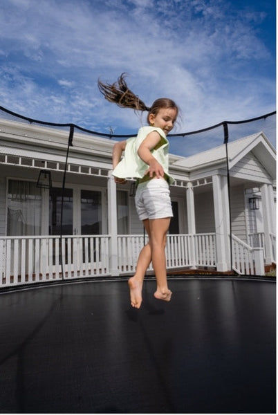 A little girl jumping on a Springfree Trampoline.