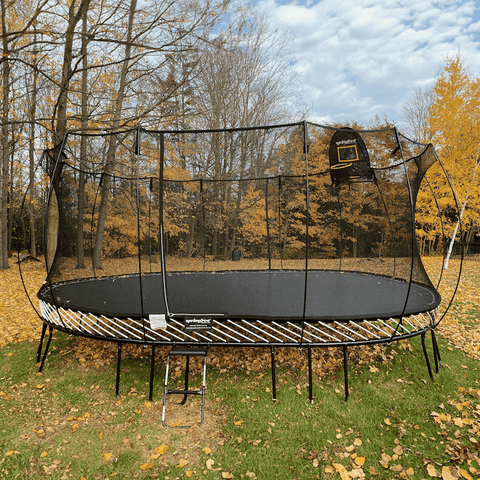 Springfree Jumbo Oval Trampoline in a backyard with leaves.