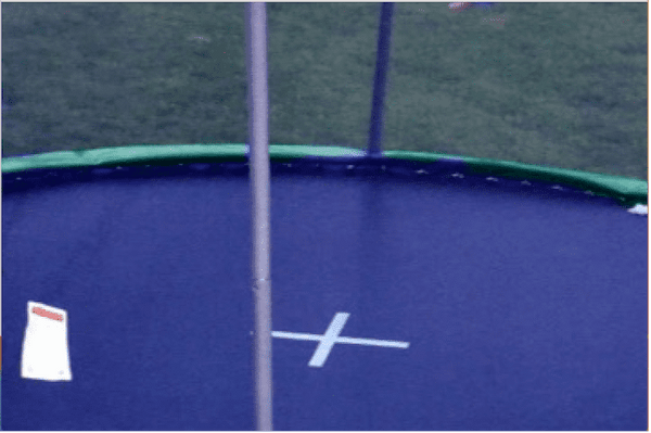 A gap between a trampoline net and mat, exposing the trampoline springs.