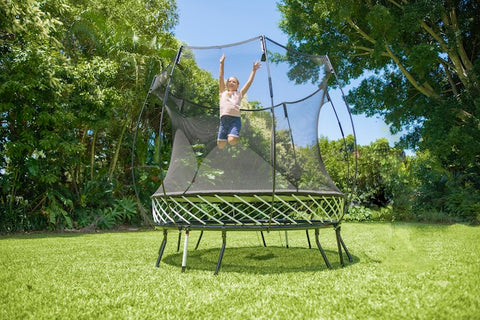 A little girl jumping on an 8 ft Springfree Trampoline.