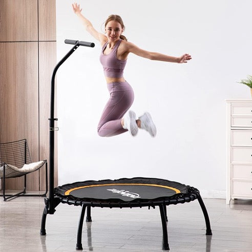 A woman jumping in mid-air on a rebounder.