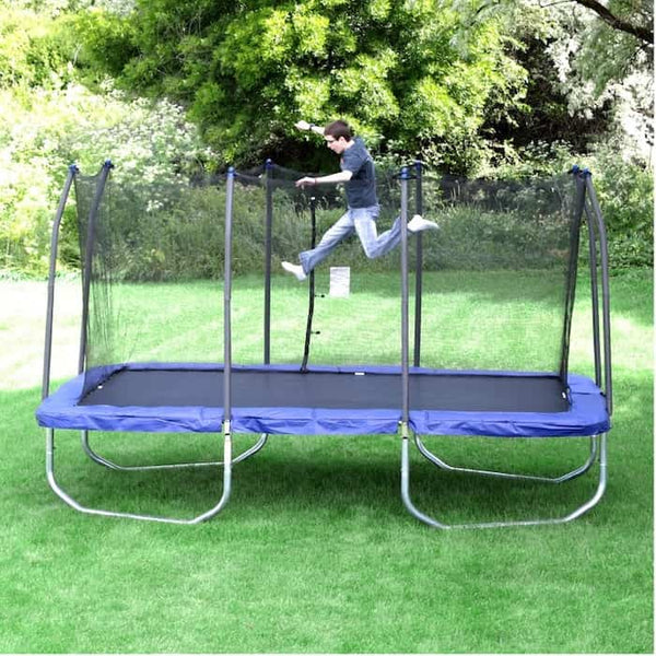 A boy jumping on a blue rectangle trampoline.